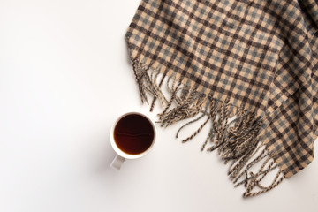 Cup of tea and a warm scarf, isolated on white background. Flat lay.