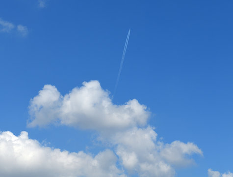Heavenly landscape with plane in distance and cumulus clouds