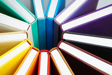 Books for colorful background. A lot of books with bright covers lined in circle. Design element, paper and leather texture, close up  