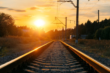 Empty railway track in sunny summer sunset