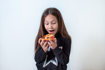 Little brunette girl eating pizza