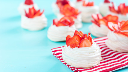 Beautiful pavlova cakes with strawberries on a blue background. Selective focus. Tasty sweet breackfast. Wedding morning. Meringue with cream.
