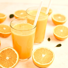 freshly squeezed orange juice in glasses on the kitchen table with slices of oranges, concept of diet and healthy lifestyle