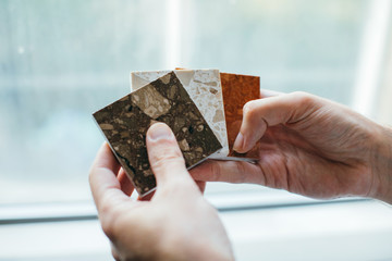 Fototapeta premium Architect is demonstrating samples of materials. Hands close up