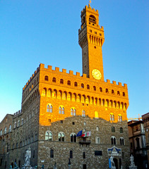 Obraz premium Palazzo Vecchio at piazza Della Signoria, Florence Italy. Famous historical building with bell tower with clock on blue sky background. Currently old Palace serves as a town hall.
