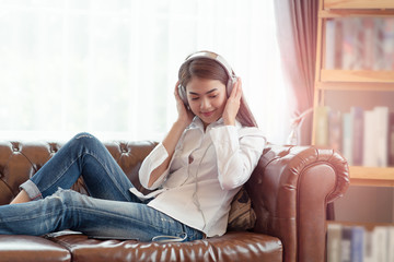 Obraz premium Young Asian woman enjoy listening to music with headphones, happy and relaxing time