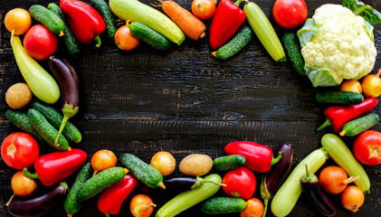 Autumn harvest. Vegetables - tomatoes and cucumbers, carrots and cauliflower, zucchini and eggplant, onions and potatoes on an old wooden background.