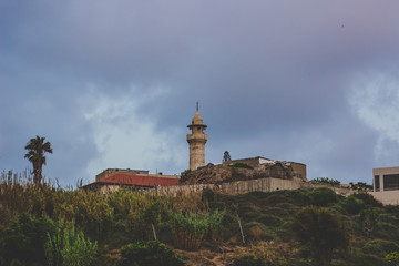 Fototapeta na wymiar light house country side rural tower building on hill in cloudy rainy stormy weather time 