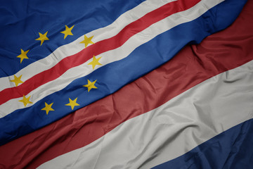 waving colorful flag of netherlands and national flag of cape verde.