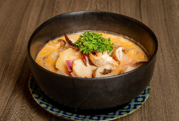 Tomyum in the black bowl.