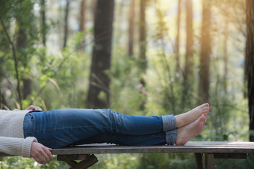 Feet of adult woman sleep in the forest on nature.