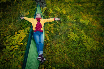 Woman resting in hammock outdoors. Sleeping outdoors.