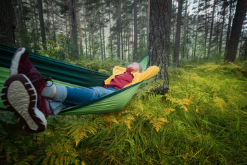 Woman resting in hammock outdoors. Sleeping outdoors.