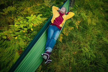 Woman resting in hammock outdoors. Sleeping outdoors.