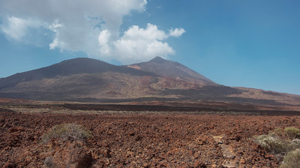 Fototapeta na wymiar Pico del Teide and Pico Viejo in Teide National Park surrounded by the arid landscape created by volcanic eruptions: igneous rocks, solidified lava and volcanic ash, in Tenerife, Canary Islands, Spain