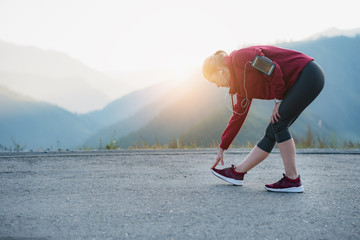 Running stretching. Athlete at the top of the mountain.