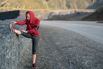 Running stretching. Athlete at the top of the mountain.