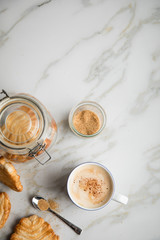 Italienische Blätterteig Fächer Kekse mit Einmachglas und Becher Kaffee auf Marmor Hintergrund