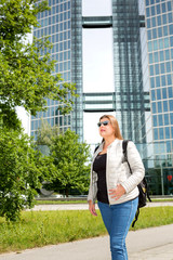 Professional lady walks to work in the city with her backpack.