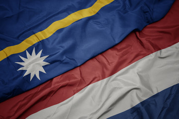 waving colorful flag of netherlands and national flag of Nauru .