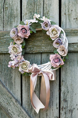 Beautiful hand made Christmas or autumn wreath decorated with a bow, flowers, ornaments on the...