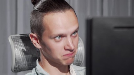 Handsome young man video calling using his computer. Attractive man video chatting through his computer, waving to the web camera. Communication, relationships concept