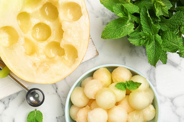 Flat lay composition with melon balls on white marble table