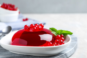 Delicious jelly with berries and mint on table