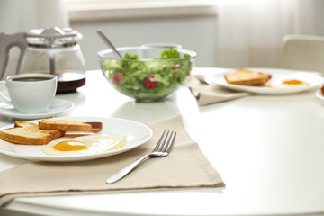 Tasty breakfast served on table in light room