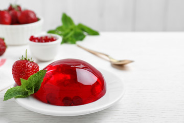 Delicious fresh red jelly with berries and mint on white wooden table, space for text - obrazy, fototapety, plakaty