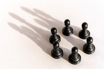 Plastic chess pawn circle with shadow shaped as crown on white background. Teamwork, group agreement and success concept