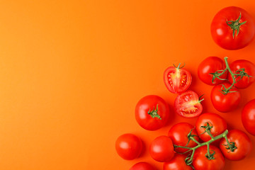Flat lay composition with fresh ripe tomatoes on orange background. Space for text