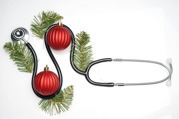 Celebrating Christmas in the healthcare industry. Conceptual. Top view of flat lay. Stethoscope with ornaments on a white background.