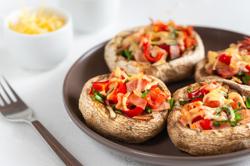 Mushrooms stuffed with bacon, tomato, red pepper, chives and cheese.