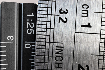 Close-up picture of two steel rulers showing the size difference between inches and centimeters....