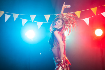 Carnival, dancer and holiday concept - Beauty brunette woman in cabaret suit and headdress with natural feathers and rhinestones.
