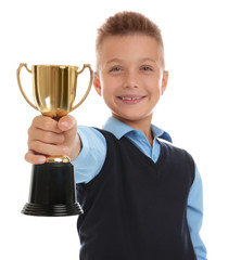 Happy boy in school uniform with golden winning cup isolated on white