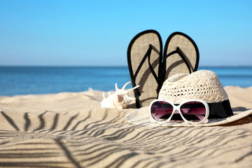Naklejka premium Stylish beach accessories on sand near sea