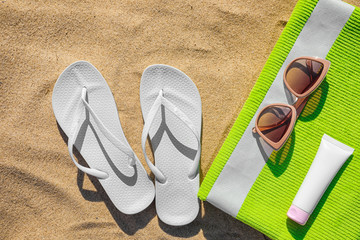 Flat lay composition with different beach accessories on sand