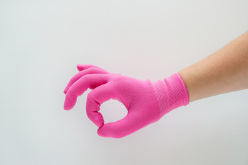 Hand in pink gloves showing sign - all is well, ok, on white background