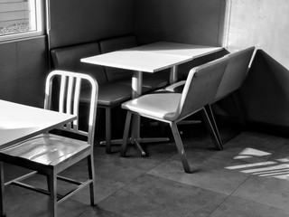 Chairs and table in the empty restaurant.The sun shines into the dining room. Sunlight hits objects.monochrome style.black and white color.