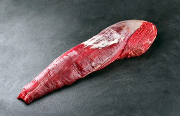 Dry aged Rinderfilet Steak natur angeboten als closeup auf schwarzen Hintergrund mit Textfreiraum