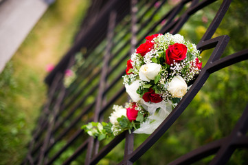 A bride's bouquet is inserted into a fence
