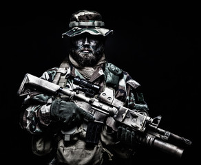 Commando soldier in battle ammunition, armed rifle
