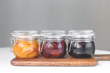 jars with different jam on a gray background