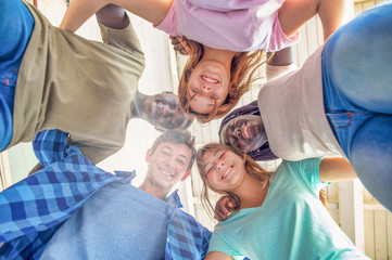 Upward view of multi ethnic group of happy teenagers smiling to the camera