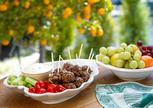 Table Snacks, Meat balls and Salad with fruit in garden setting