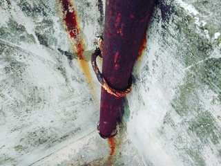 Old Rusty Iron Metal Pipe On The Concrete Wall Supported by Rusty Iron Metal Rings