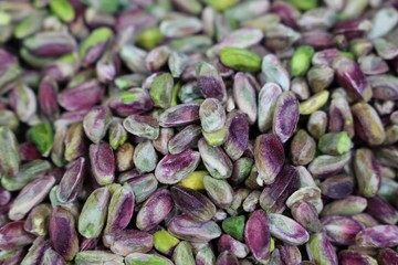 Pistachios in white porcelain bowls. Roasted pistachio seeds in shells and shelled