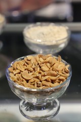 Pistachios in white porcelain bowls. Roasted pistachio seeds in shells and shelled